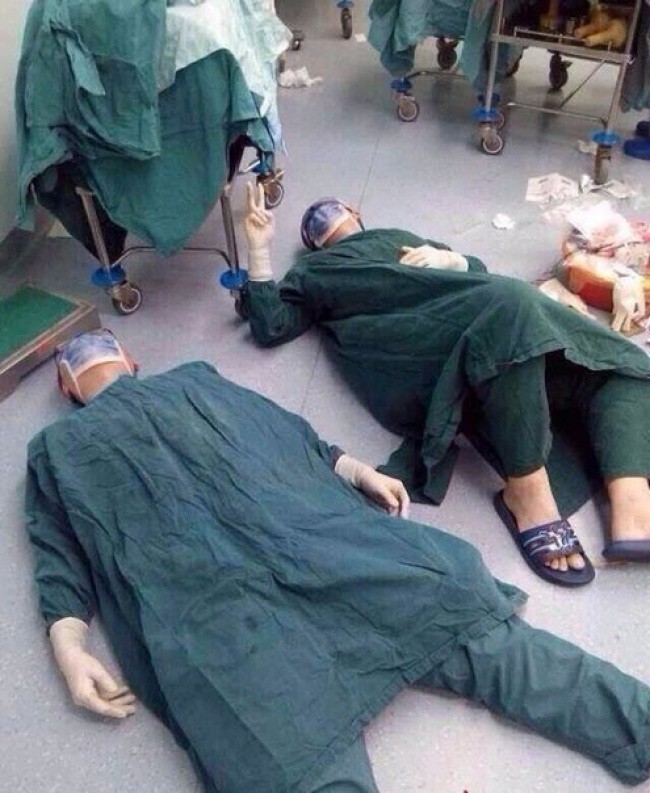 2 chirurgów odpoczywa po udanej operacji usunięcia kilku guzów mózgu, która trwała 32 godziny