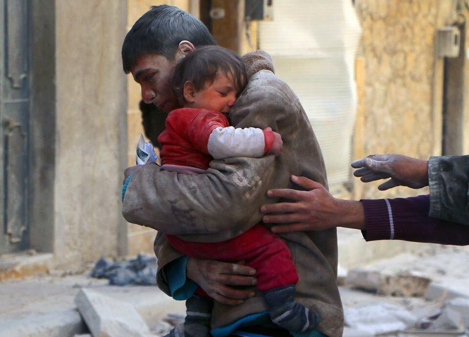 2. Chłopak ratuje swoją siostrę spod gruzów ich domu w Syrii.