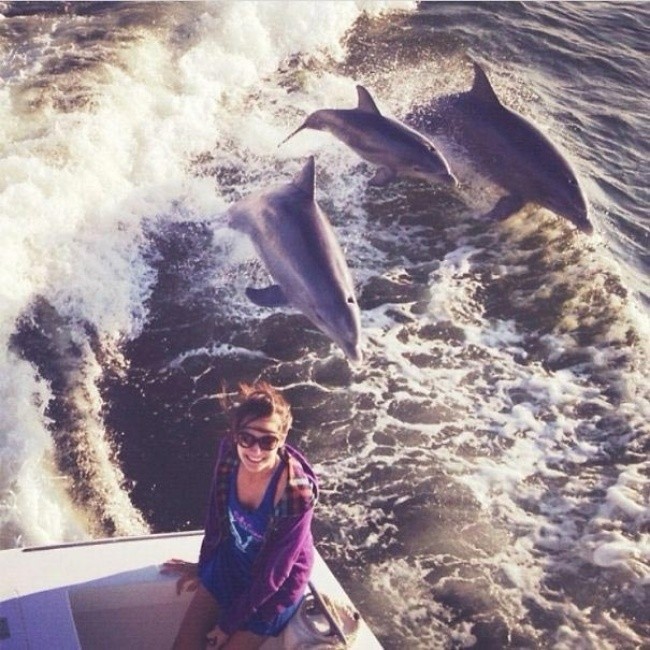 25.  „Pływałam łodzią wraz z moją rodziną. Usiadłam na krawędzi aby zrobić sobie piękne zdjęcie z falami w tle, gdy nagle z wody wyskoczyły dwa dorosłe delfiny wraz z ich młodym. To był idealny moment na zdjęcie”.