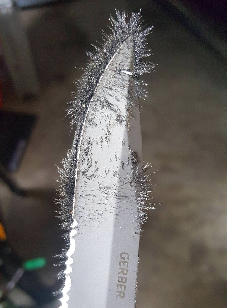 Namagnesowane opiłki metalu na krawędzi noża 