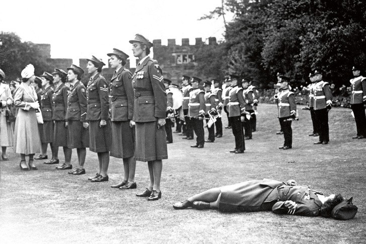 Młoda kobieta mdleje z gorąca pełniąc wartę honorową w Królewskim Korpusie Kobiet w Shrewsbury, Anglia, 6 lipca 1949 rok