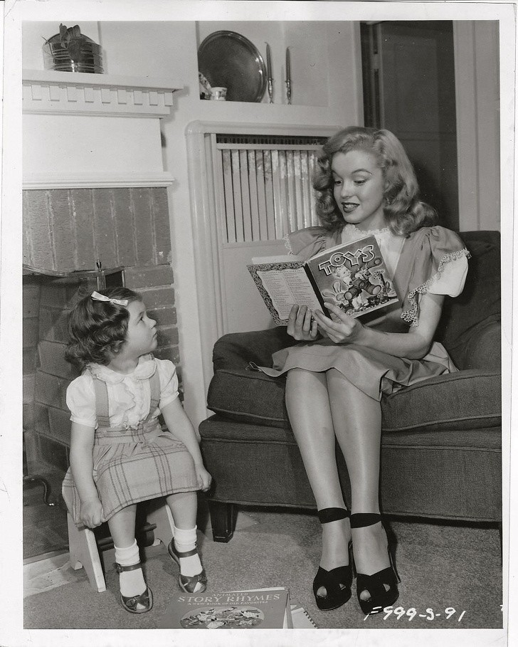 Młoda Marilyn Monroe opiekuje się dzieckiem pracownika studia.