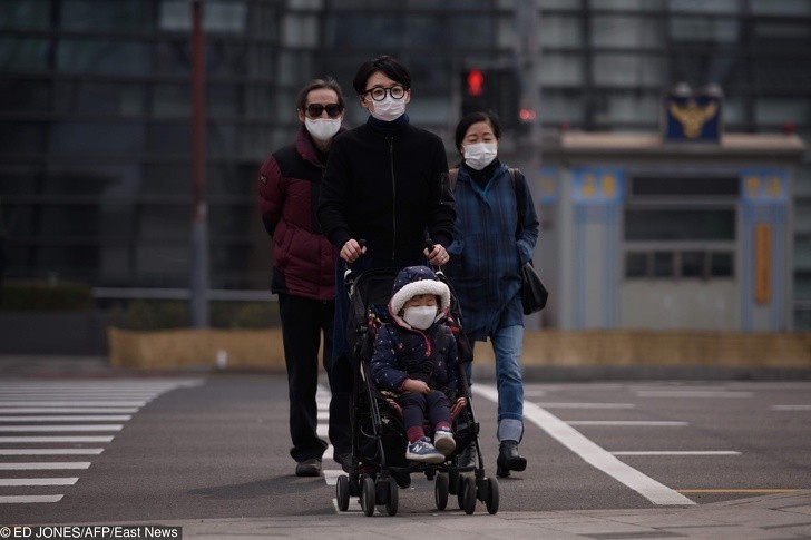 Rodzina nosząca maski podczas szczególnie zanieczyszczonego dnia w Seulu.