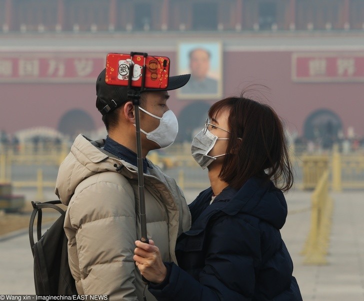 Chińska para nosząca maski podczas selfie wykonanym w Pekinie.