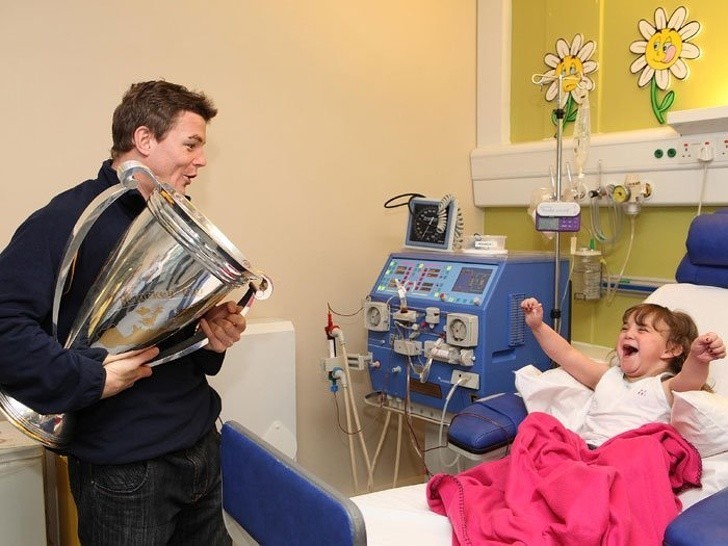 Irlandzki rugbysta Brian O'Driscoll odwiedza młodą fankę w szpitalu z pucharem Heinekena