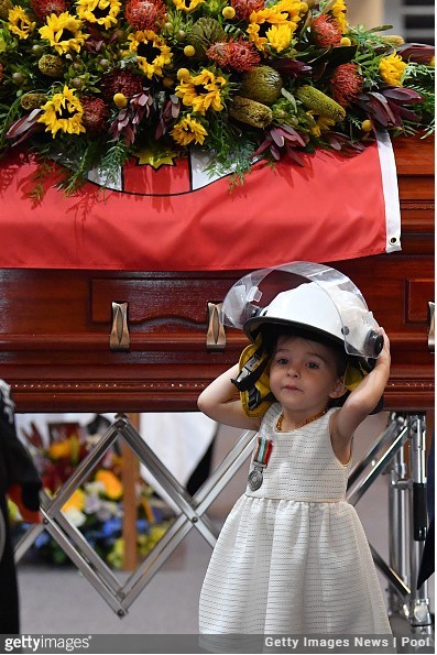 Córeczka zmarłego strażaka z ochotniczej jednostki podczas jego pogrzebu.