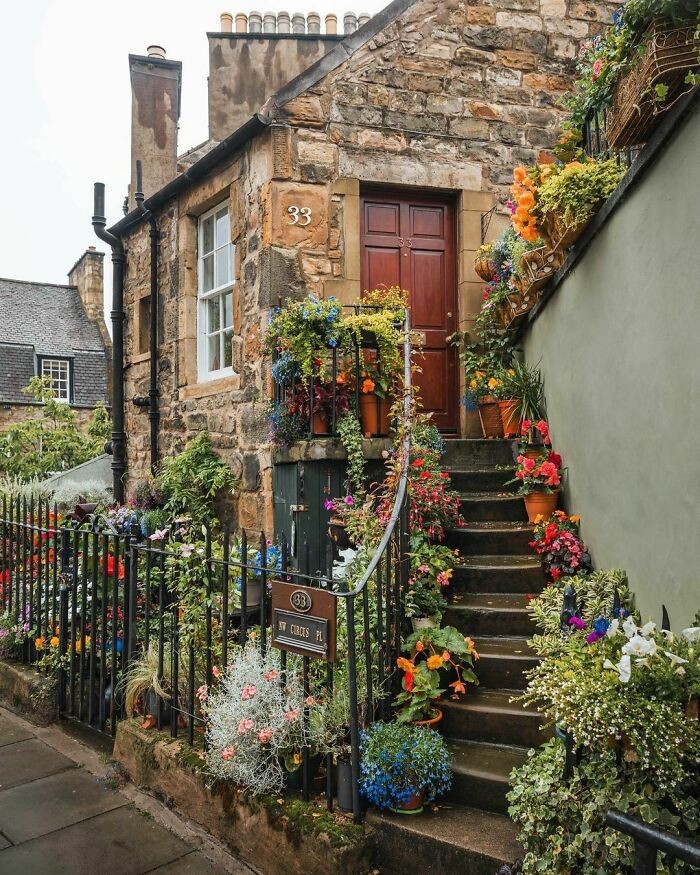Drzwi do kamiennego domku ozdobione kwiatami, Edynburg, Szkocja