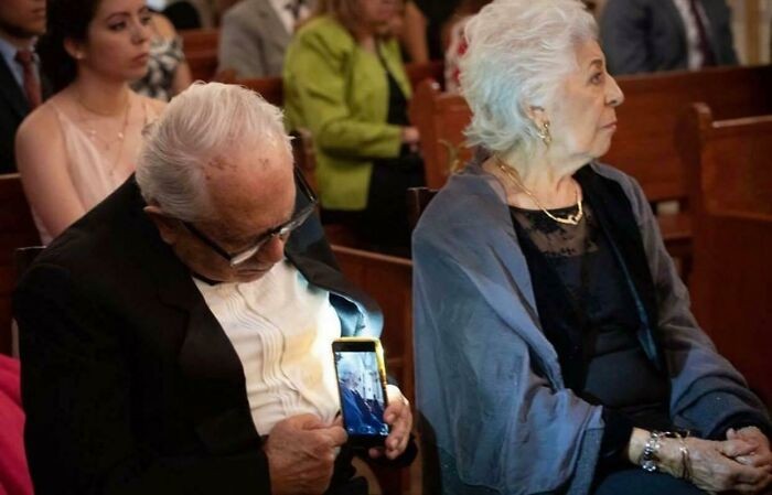 Starszy mężczyzna robi zdjęcie swojej nieświadomej żonie.