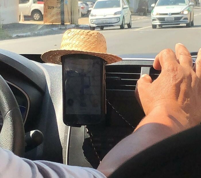 Kierowca Uber nałożył słomkowy kapelusz na swój telefon.