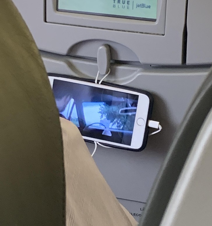 "Facet w samolocie używa kabla od słuchawek do zawieszenia telefonu."