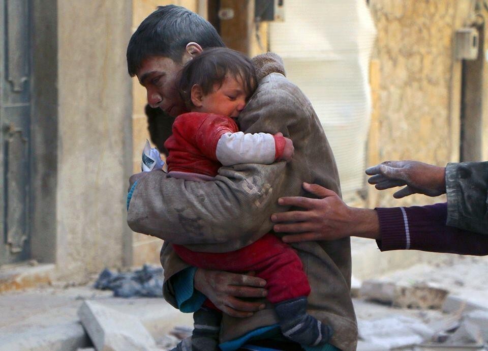 2. Chłopak ratuje swoją siostrę spod gruzów ich domu w Syrii.