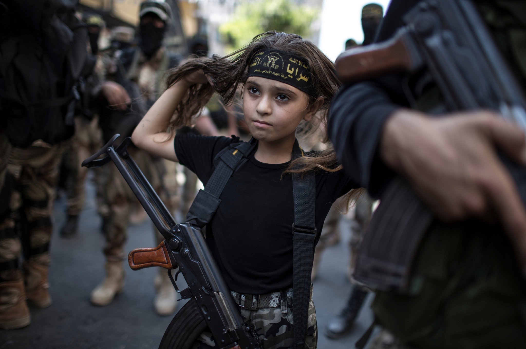 15. Palestyńska dziewczynka z Kałasznikowem, pośród islamskich żołnierzy w Gazie.