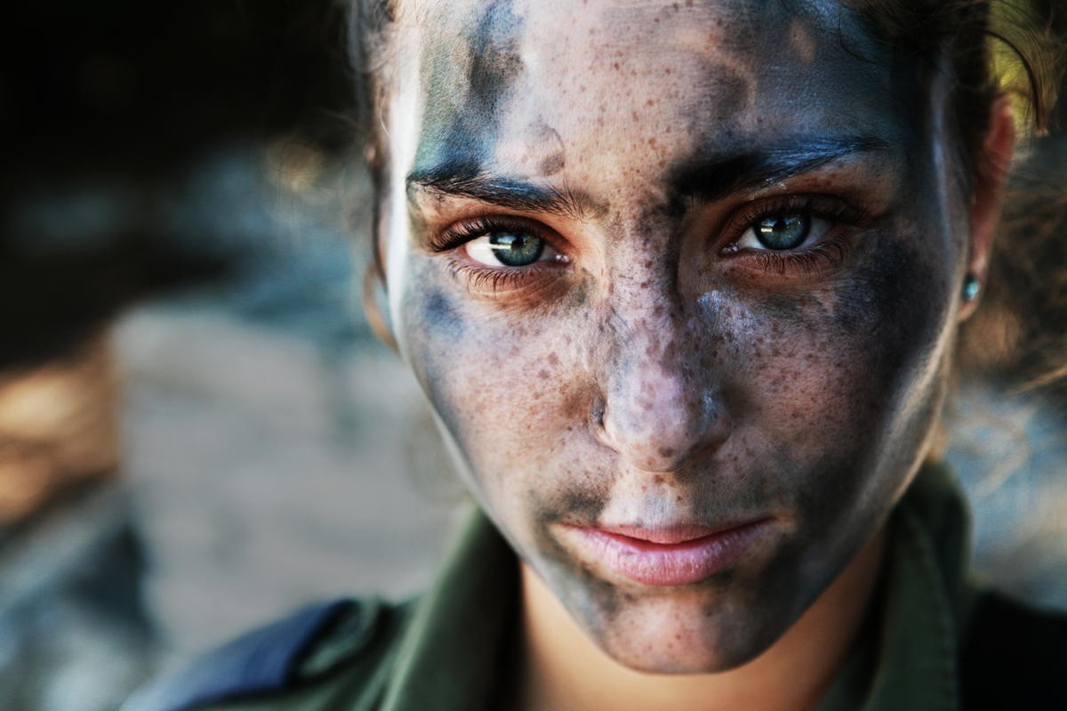 19. 18-letnia żołnierka Sił Obronnych Izraela, odpoczywająca po długim marszu w pełnym rynsztunku i barwach maskujących.