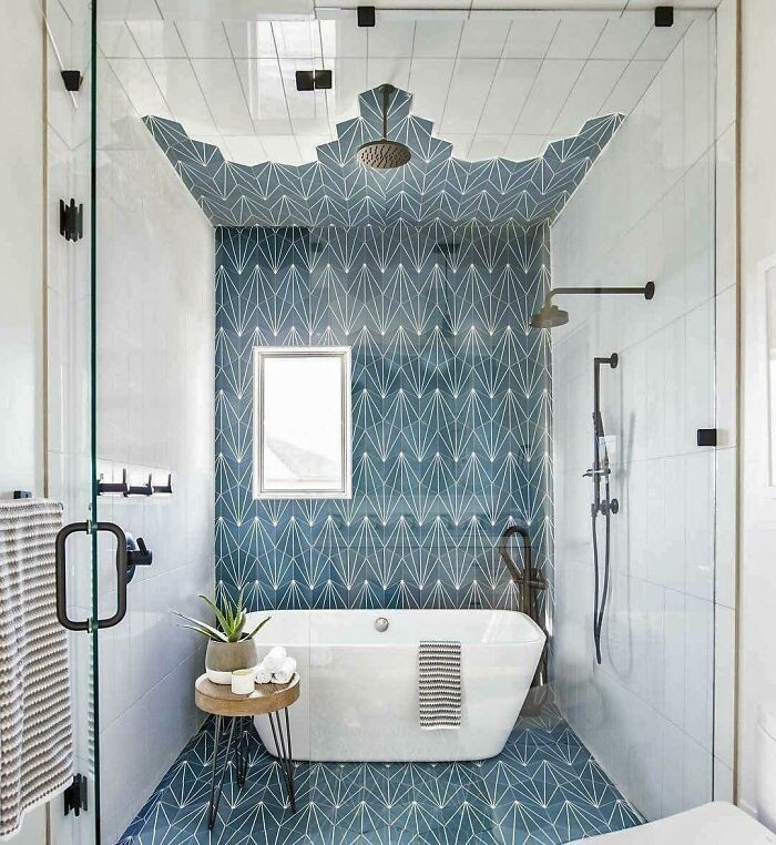 Łazienka z geometrycznymi niebieskimi kafelkami wspinającymi się na sufit