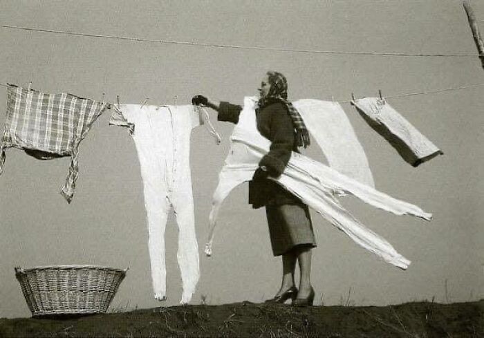 Kobieta zdejmująca zamrożone kalesony ze sznurka, 1940