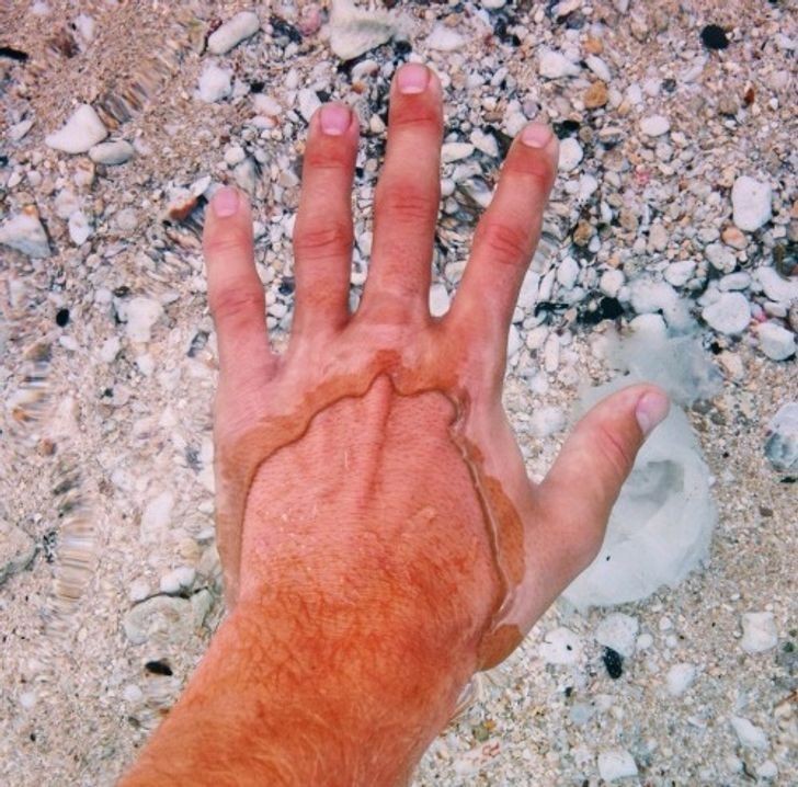 1. Woda jest tak czysta i spokojna, że jego dłoń wygląda jakby miała dwie warstwy skóry.