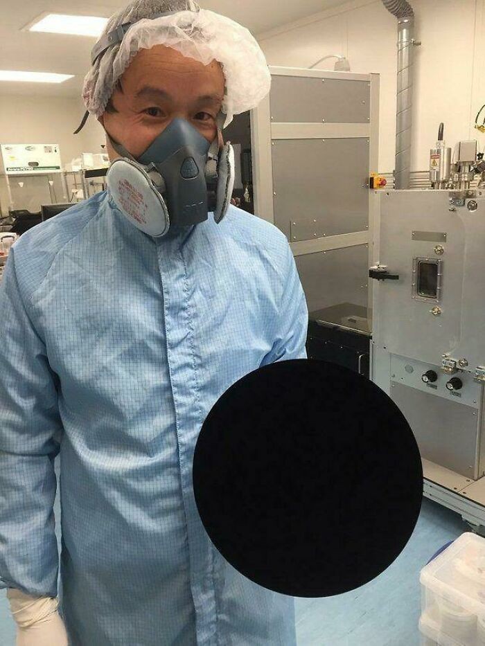 Naukowiec trzymający piłkę pokrytą vantablack - najczarniejszą substancją na świecie
