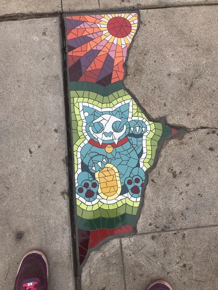 3. Pęknięcie w chodniku wypełnione mozaiką z portretem kota