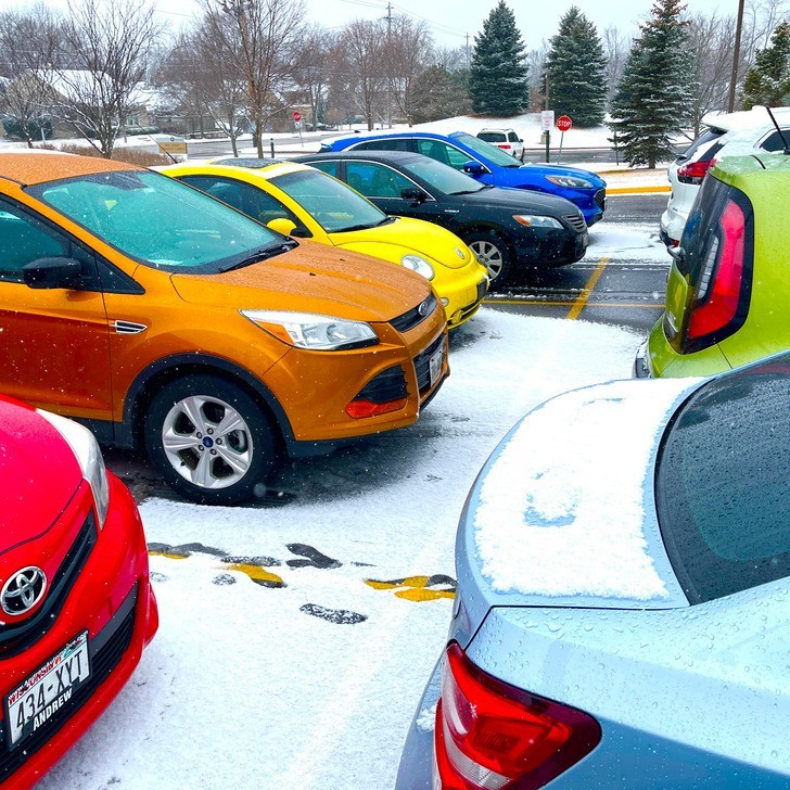 "Tęczowy parking przed przedszkolem podczas śnieżnego poranka"