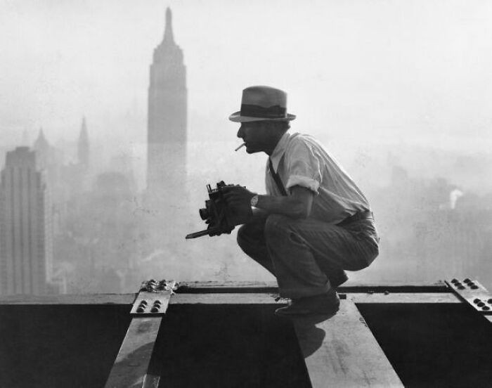 6. Charles Ebbets w trakcie fotografowania "Lunchu na szczycie wieżowca", ikonicznego zdjęcia nowojorskich robotników jedzących lunch na wiszącej metalowej belce