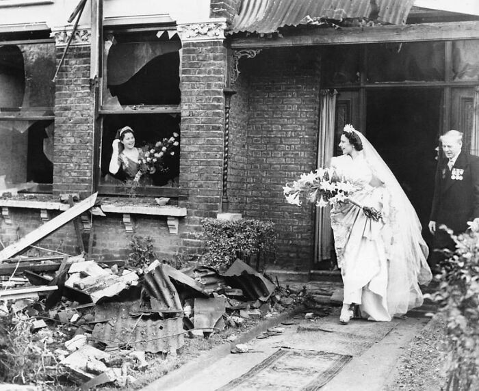 Panna młoda wychodząca ze swojego niedawno zbombardowanego domu, by wziąć ślub. Londyn, 1940
