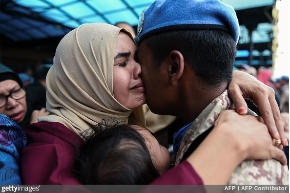 6. Żołnierz przytulający swoją rodzinę przed odlotem