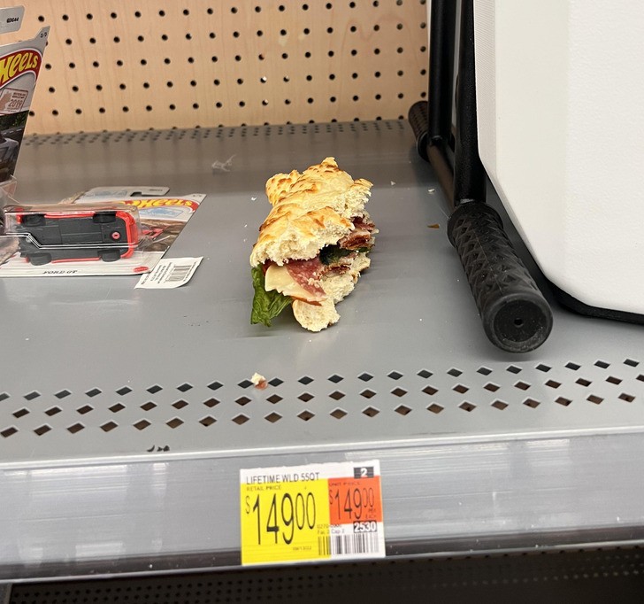 "Ktoś zostawił niedojedzoną kanapkę na regale w sklepie, zamiast wyrzucić ją do kosza."