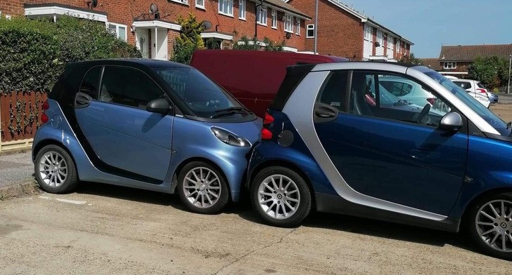 "Dwa Smarty zaparkowane na jednym miejscu parkingowym"