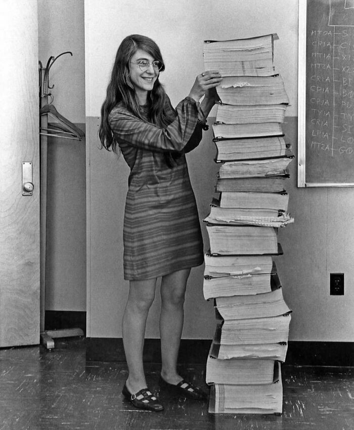 4. Informatyczka Margaret Hamilton stojąca przy ręcznie napisanym kodzie oprogramowania systemu pokładowego programu kosmicznego "Apollo", 1969
