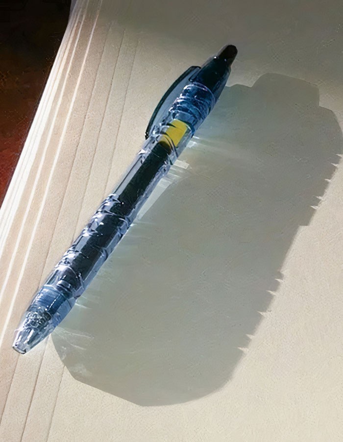 "Długopis wykonany z butelek poddanych recyklingowi rzuca cień w kształcie butelki."