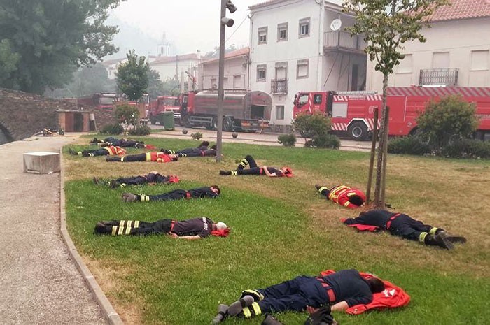 "Wyczerpani strażacy odpoczywający po walce z pożarami w Portugalii"