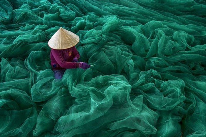 "Wietnamska kobieta naprawiająca sieci rybackie"