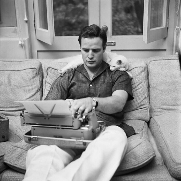 4. Marlon Brando w trakcie pisania w towarzystwie swojego kota, 1954