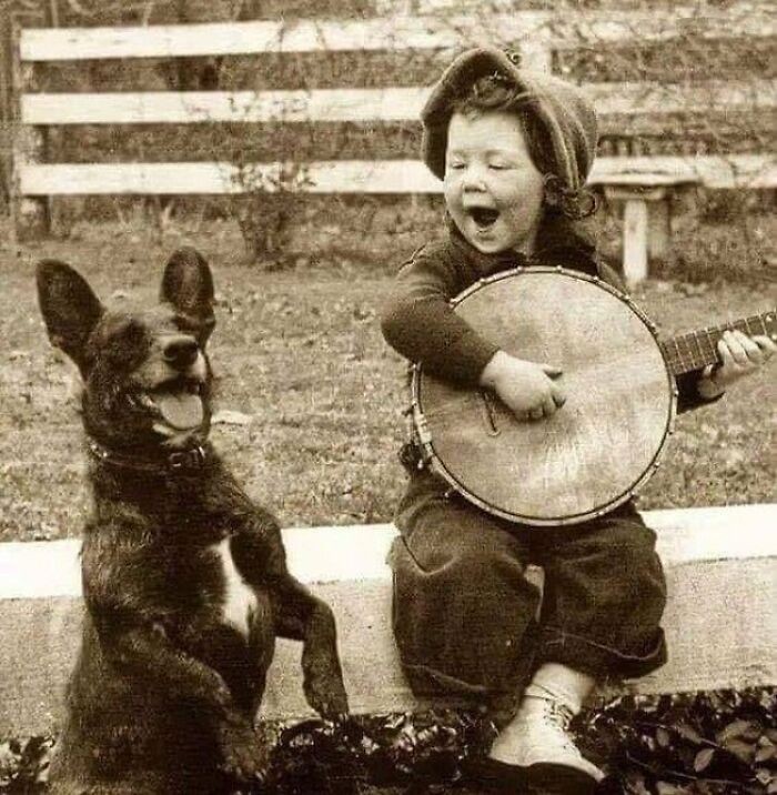 "Młody chłopiec grający na banjo i jego pies, wczesne lata 1900"