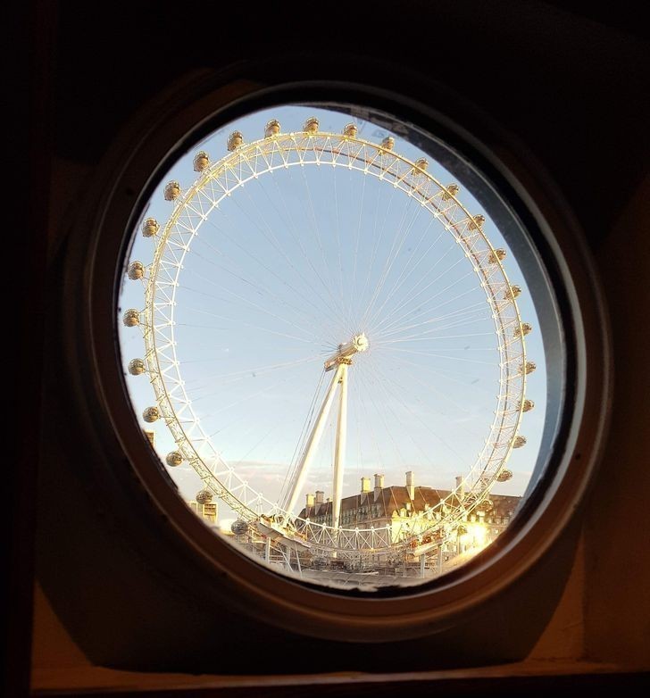 "Zdjęcie Londyńskiego Oka zrobione przez okno promu na Tamizie"