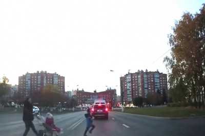 Matka roku przebiega z dziećmi przez ruchliwą drogę