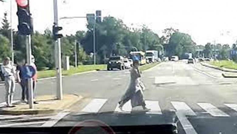 Karetka na sygnale kontra kobieta z telefonem na przejściu 