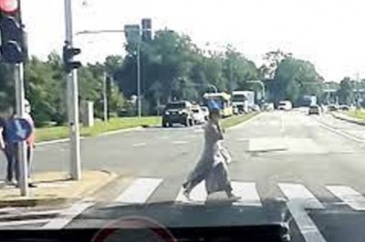 Karetka na sygnale kontra kobieta z telefonem na przejściu 